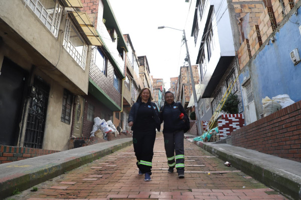 Calles de un barrio y de fondo dos mujeres caminando
