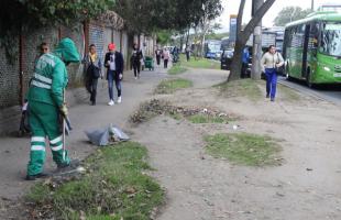 Operaria de aseo realizando barrido en la calle